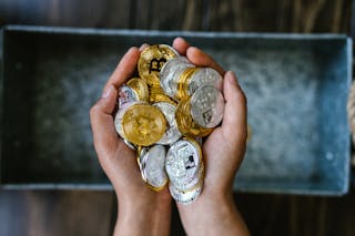 Person Holding Gold and Silver Round Coins