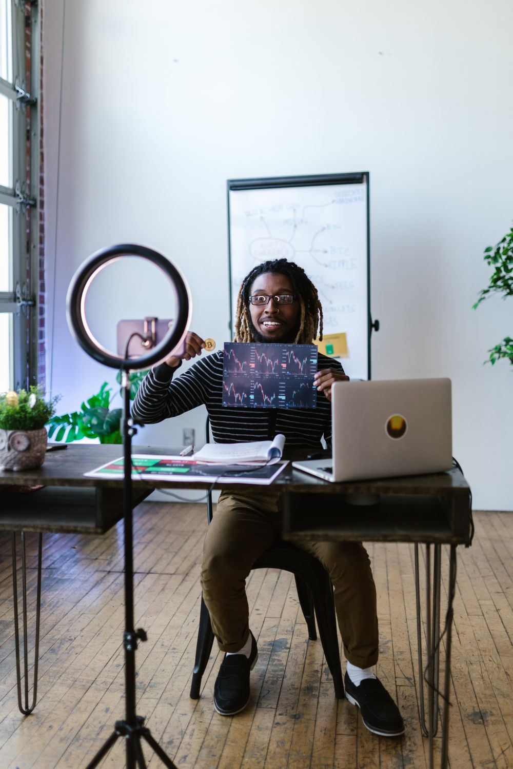 A person calculating finances with crypto graphs in the background, symbolizing dollar-cost averaging.