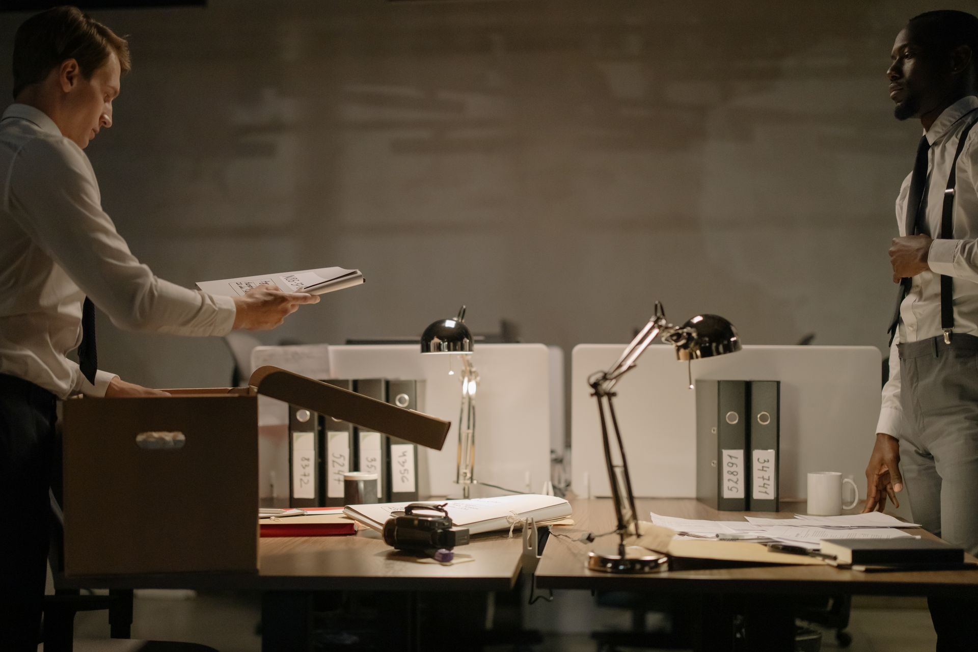 Detective Looking at His Colleague Taking Out Another Case File