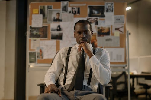 Man in White Shirt and Black Tie Sitting in an Armchair 