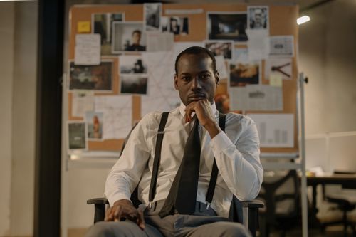 Free Focused detective in a modern office setting, analyzing a crime board. Cinematic and intense mood. Stock Photo