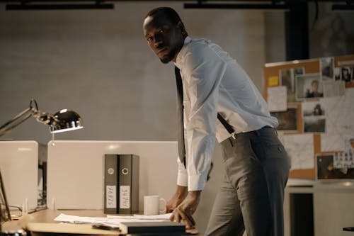 Free Man Wearing White Long Sleeves Standing Near Work Desk Stock Photo