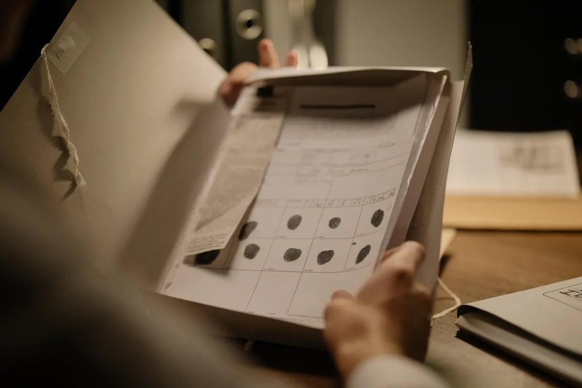 Close-up of a file containing documents with fingerprints, possibly related to a complex legal case requiring the expertise of a Supreme Court lawyer.