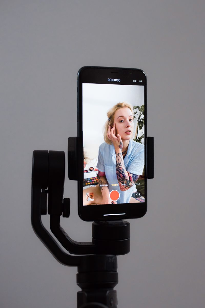 Mujer grabando un tutorial de belleza con un smartphone