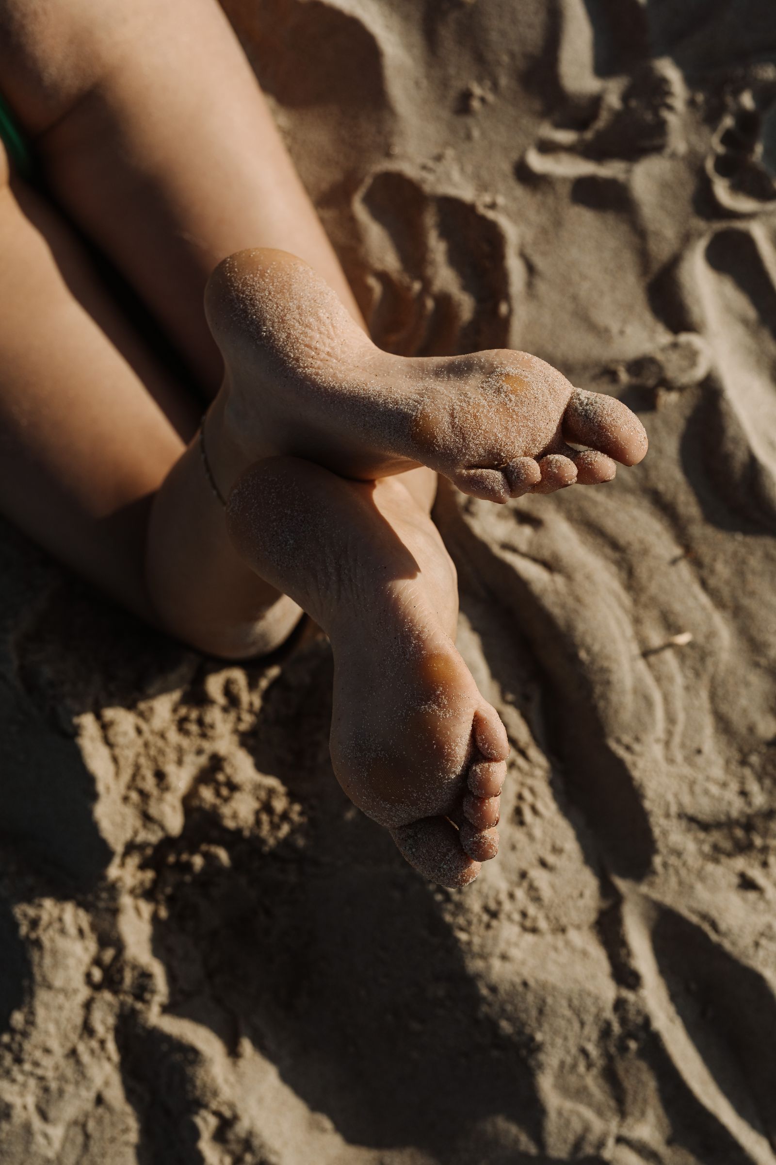 Close-up of bare feet on sandy beach