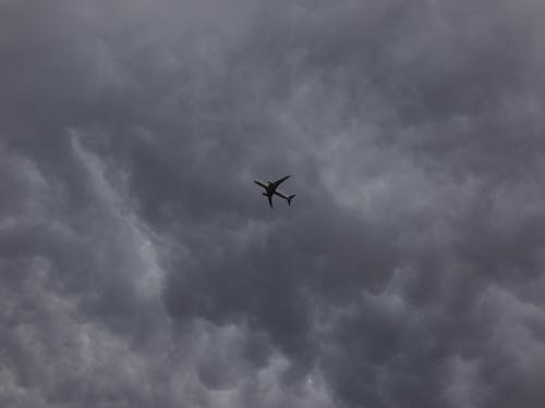 Airplane Flying Under the Dark Clouds