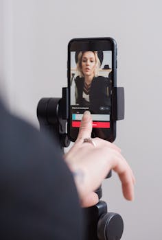A woman recording a vertical video on her smartphone, focusing on engaging digital content creation.