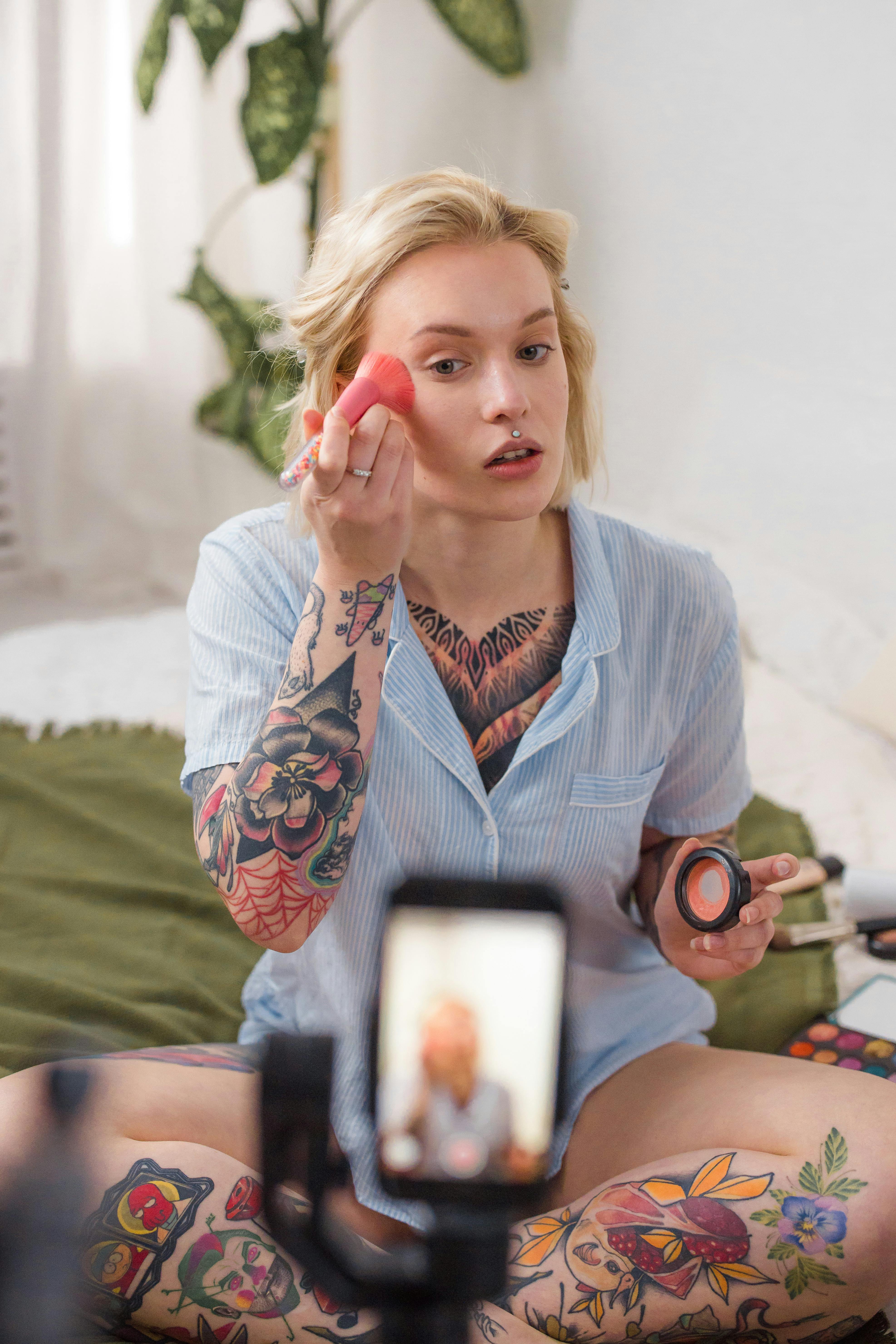 young woman filming makeup application tutorial