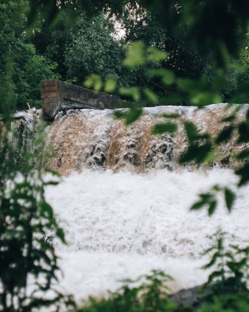 Free A tranquil waterfall cascading through a vibrant green forest, offering a peaceful natural scene. Stock Photo