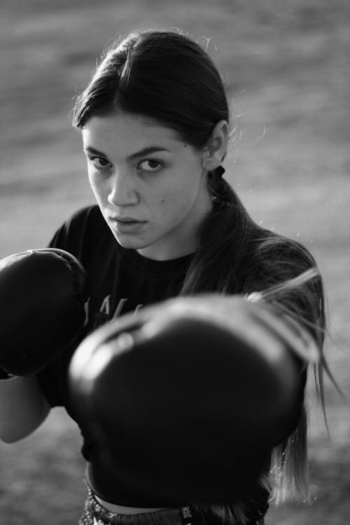 Grayscale Photo of a Woman Wearing a Boxing Gloves
