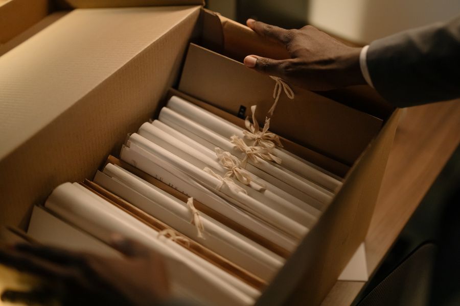 Hands organizing files in a box of documents
