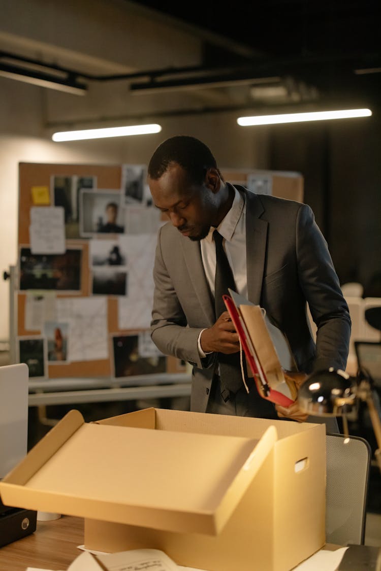 Man In Gray Suit Holding Files And Documents 