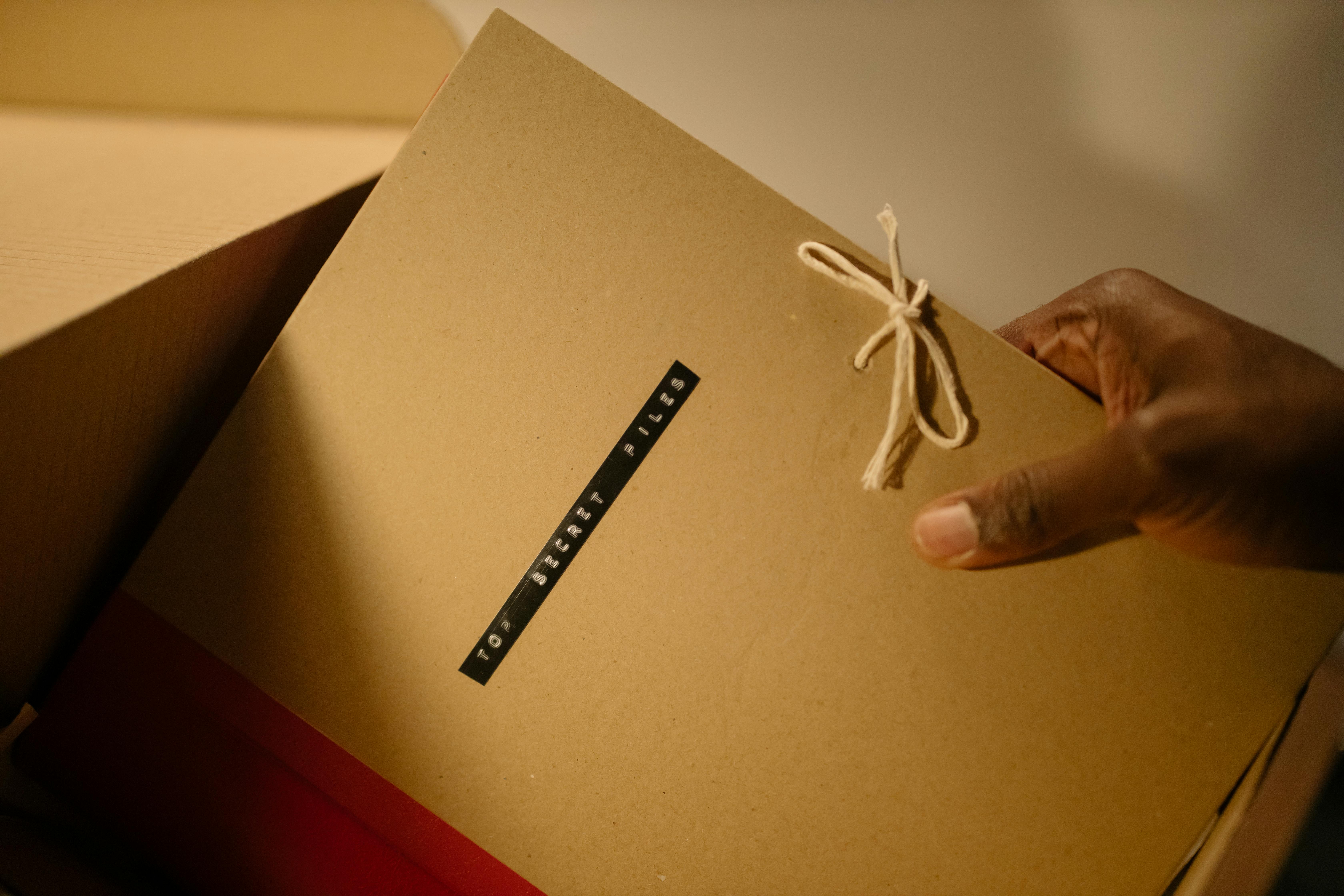 A Person Holding a Folder of a Top Secret Files Label