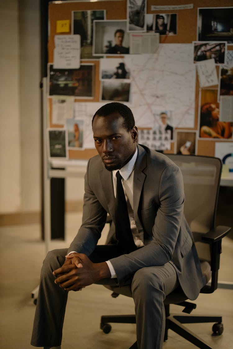 Man In Gray Suit Sitting On A Chair