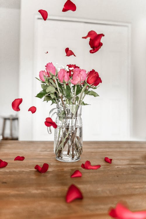 Ücretsiz şeffaf Cam Sürahi üzerinde Pembe Ve Kırmızı Güller Stok Fotoğraflar