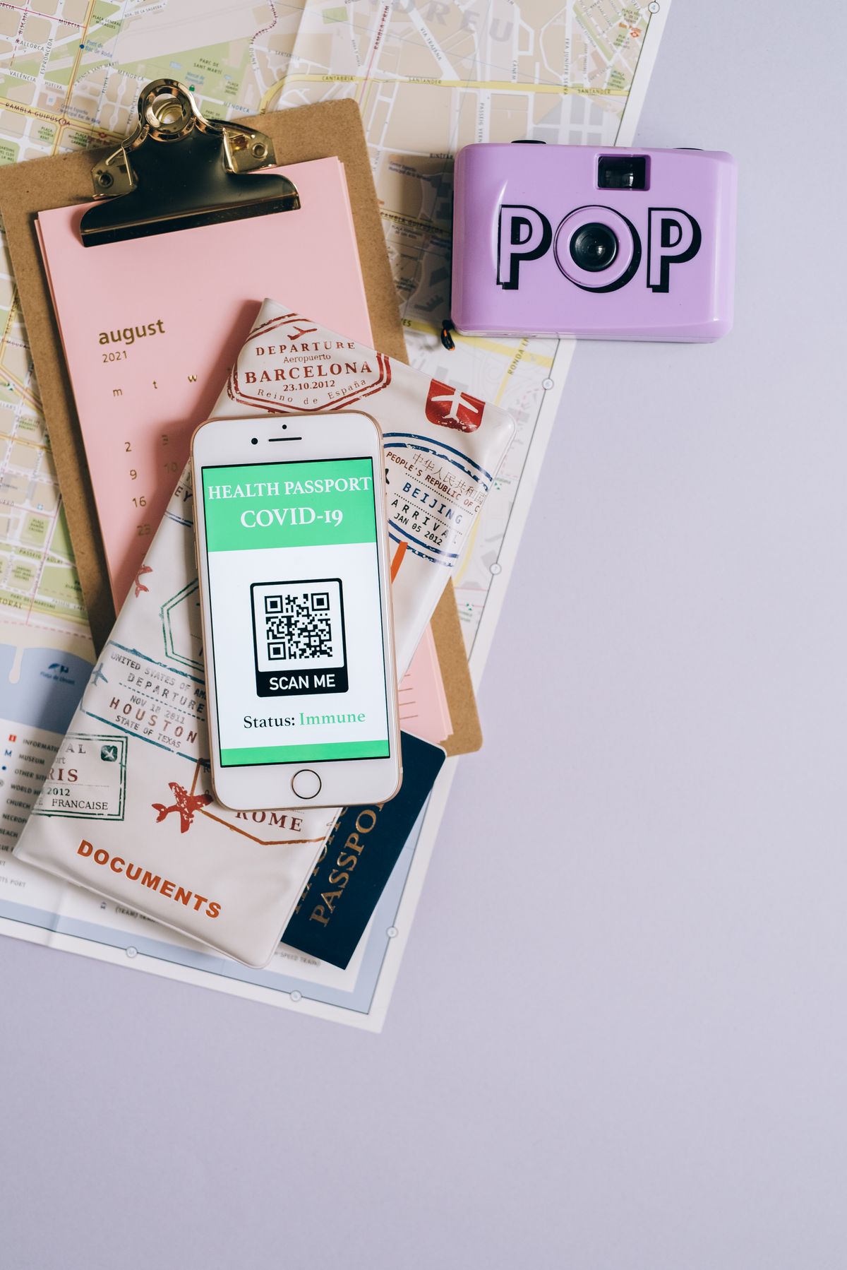 Travel documents and a digital health document arranged on a map