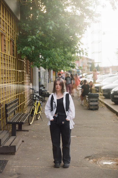 Young Girl in White Long Sleeve Shirt Walking on the Street