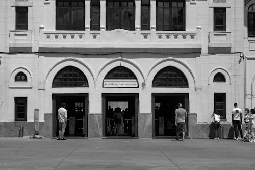 Free A Grayscale Photo of People Walking on the Street Near the Building Stock Photo