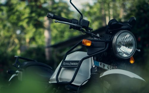 Free Close-up of a Royal Enfield motorcycle in a green outdoor Kerala landscape. Stock Photo