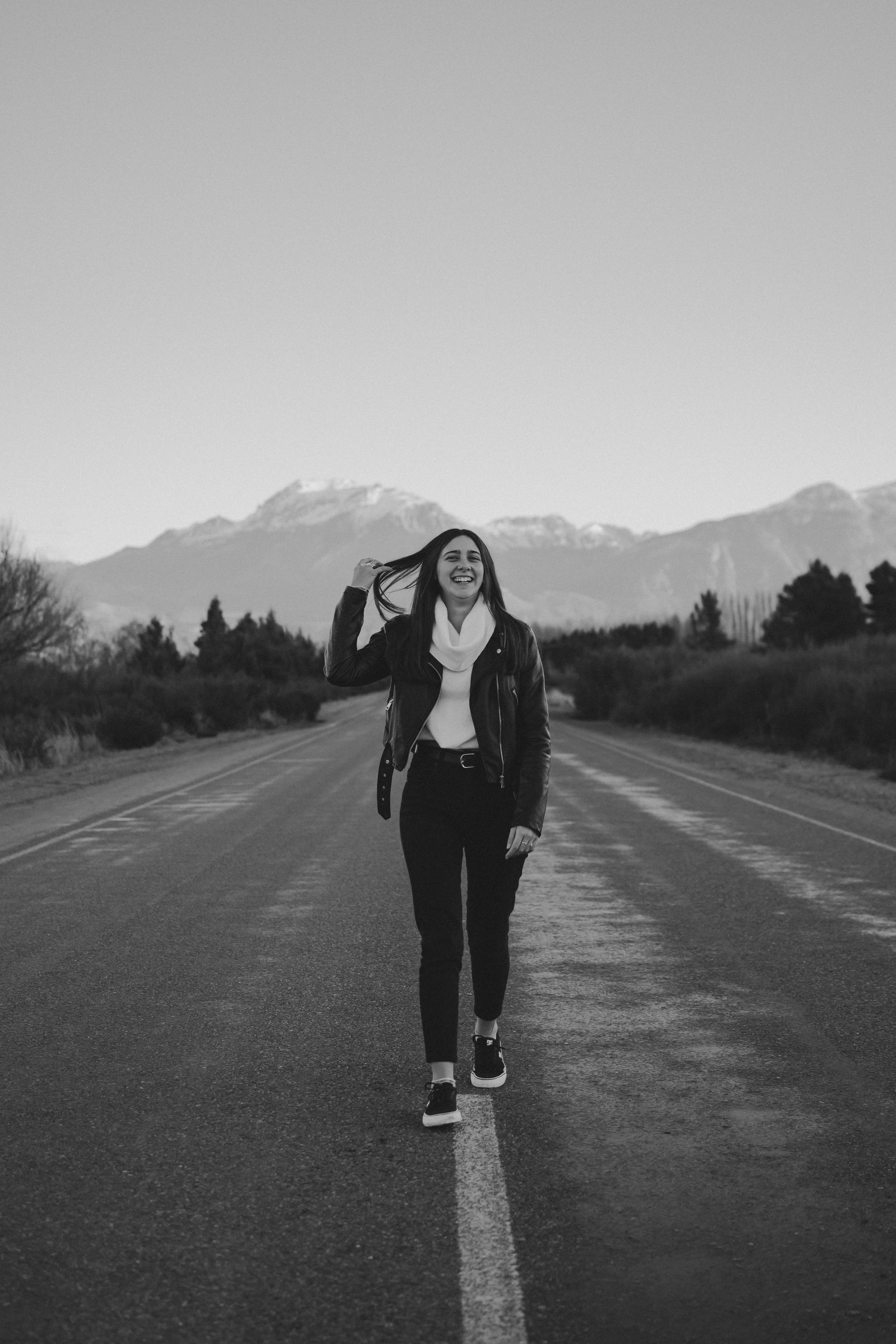 Woman in Black Jacket Standing in the Middle of the Road · Free Stock Photo
