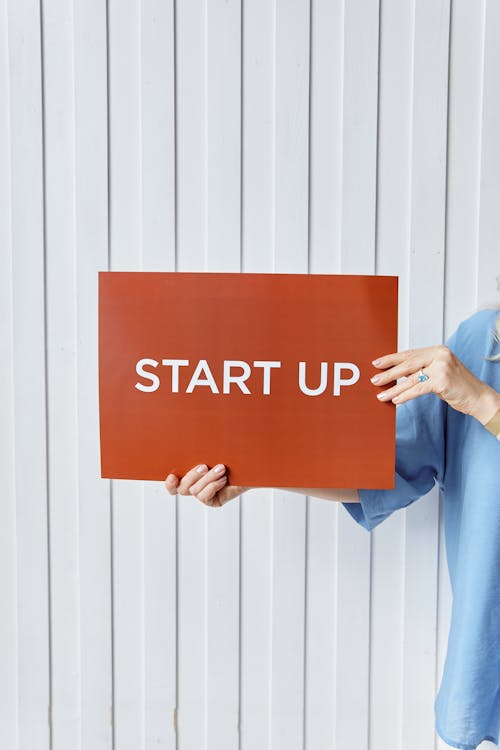 Free Person Holding a Paper with Start Up Sign Stock Photo