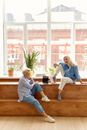 2 Women Sitting on Brown Wooden Bench
