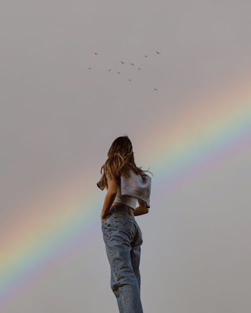Woman Standing and Looking at a Rainbow 