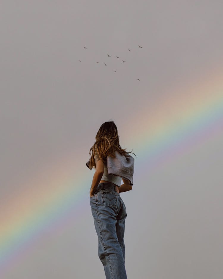 Woman Standing And Looking At A Rainbow 