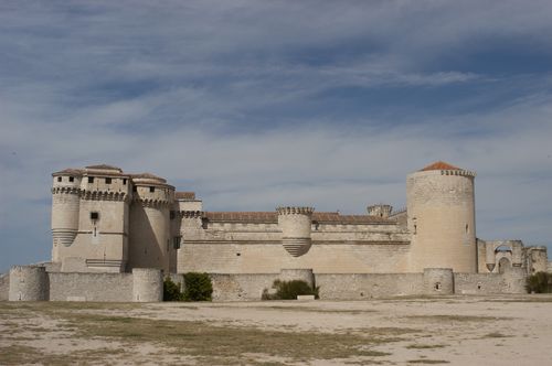 Free A grand medieval castle with robust walls and towers under a clear blue sky, showcasing historic architecture. Stock Photo