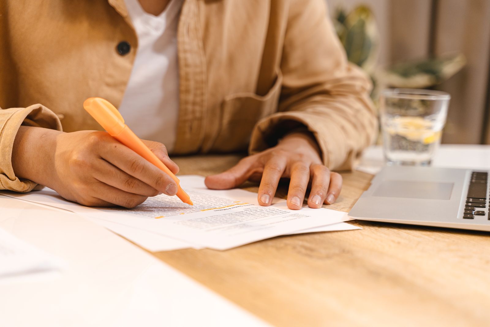 Student preparing application notes at a desk with a laptop