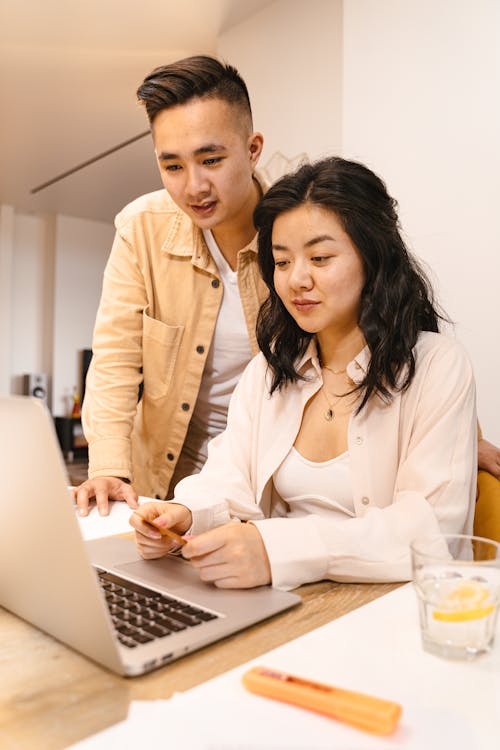 Free Woman and Man Using a Laptop Together Stock Photo