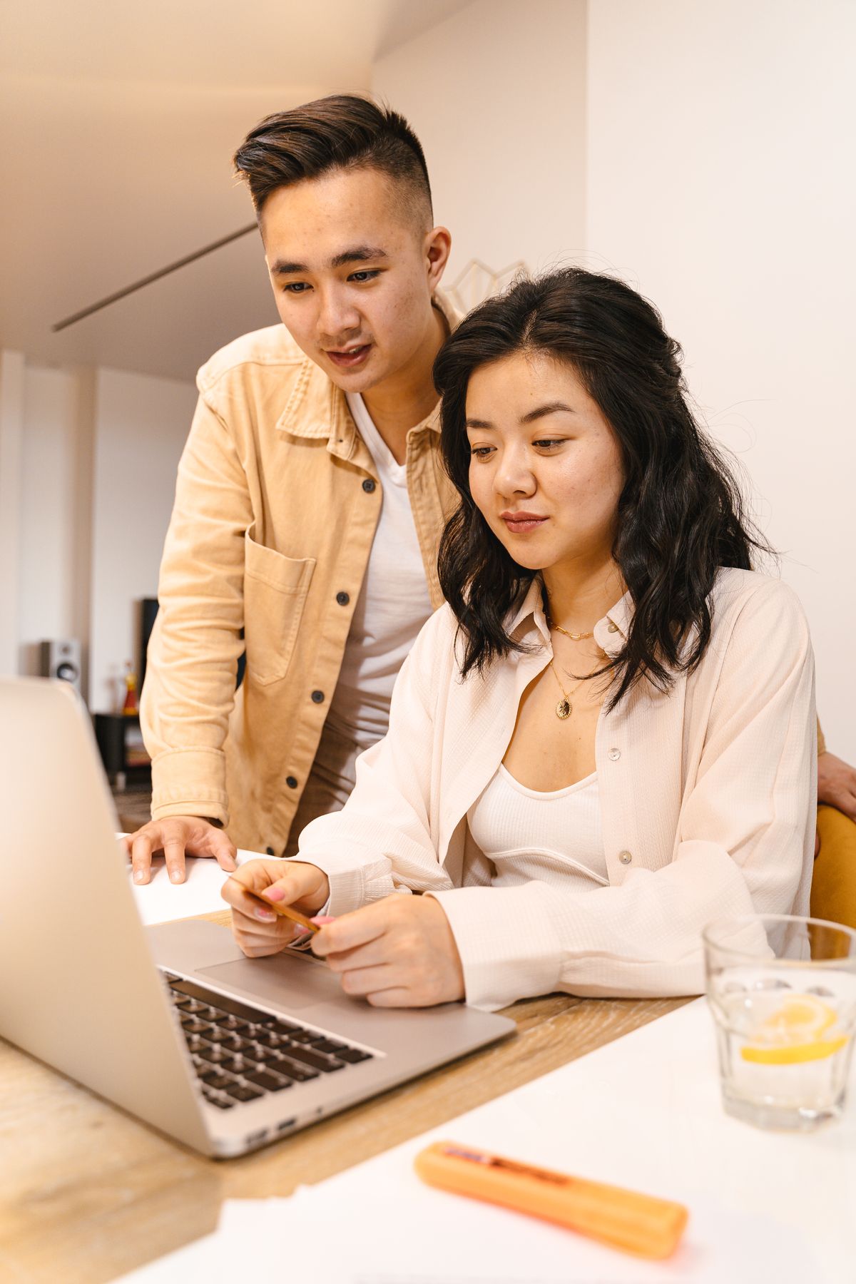 Two colleagues at a small firm working through a task together on one laptop