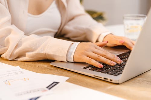 Free A Person with Manicured Nails Typing on Laptop Stock Photo