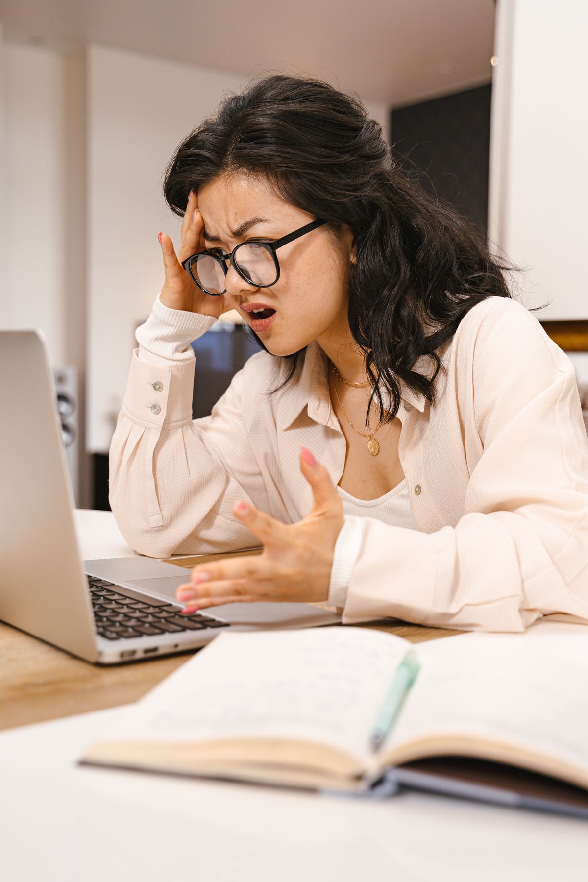 A woman looks frustrated while working at her laptop, dealing with a presentation tool problem