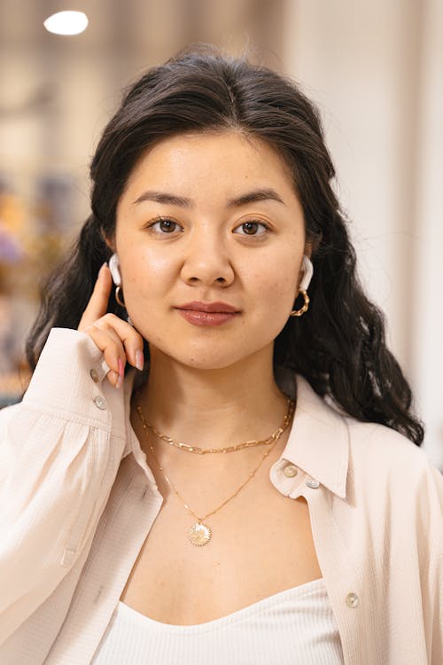 Woman Wearing Long Sleeves Shirt Holding Her Earbuds