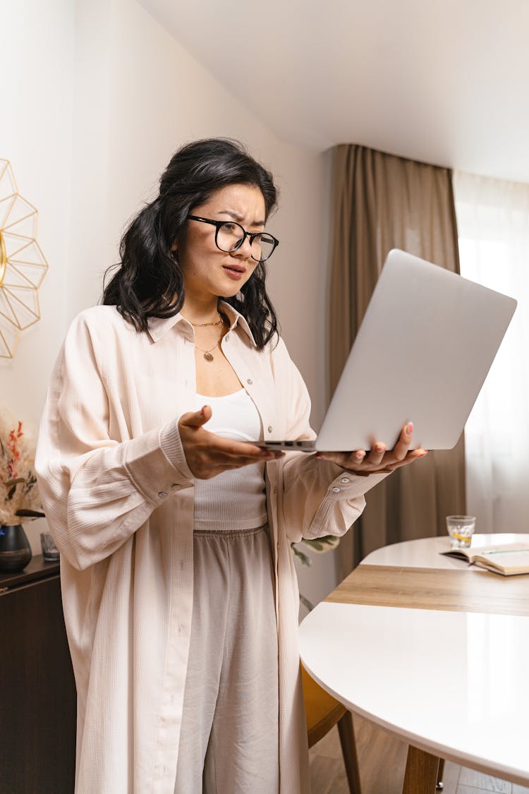 A Woman With A Frustrated Facial Expression While Looking At Her Laptop