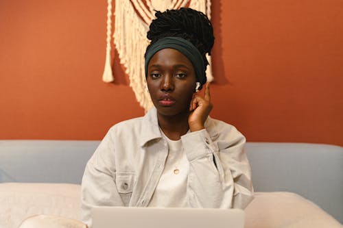 Free A Woman Tapping Her Wireless Earphones Stock Photo