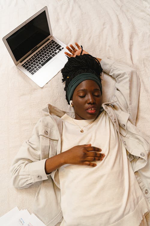 Woman Lying Beside a Laptop