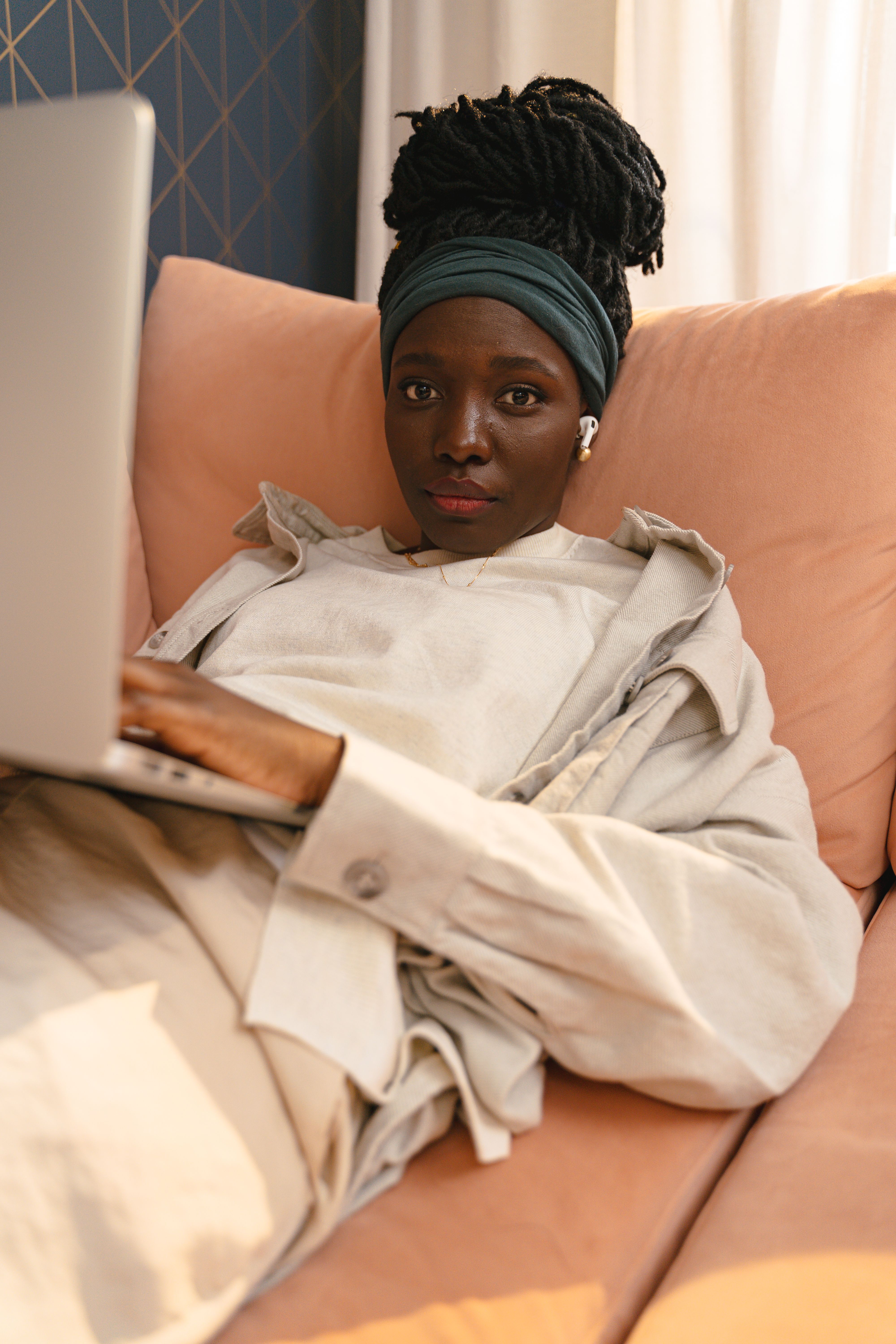 Young Woman Lying on a Couch and Using Laptop · Free Stock Photo