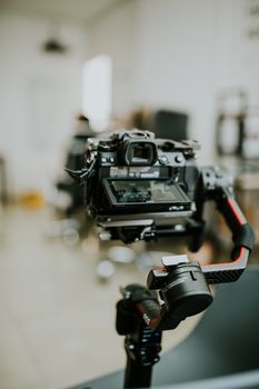 Close-up of a DSLR camera mounted on a stabilizer indoors, ideal for technology and equipment concepts.
