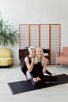 Smiling women enjoying a peaceful yoga session indoors on a cozy day.