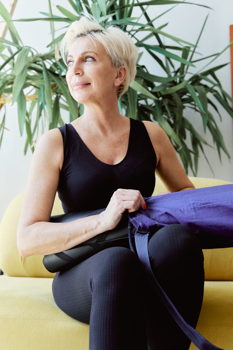 Woman In Black Tank Top And Leggings Holding A Yoga Mat 