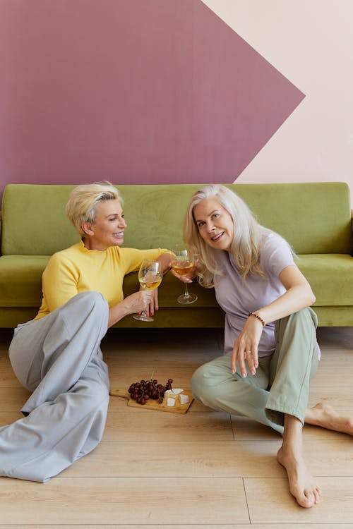Blonde Women Celebrating at Home with Wineglasses