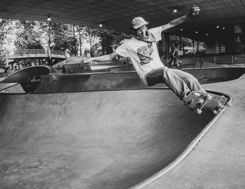 Free Black and white photo of a skateboarder performing a trick in an urban skate park. Stock Photo