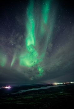 Majestic northern lights illuminate a starry night sky over a serene landscape.