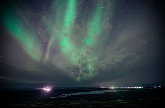 Capture of the vibrant aurora borealis lighting up the night sky over a serene landscape.