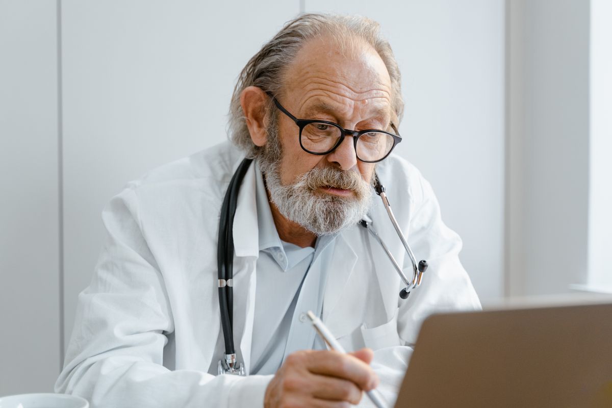 Person thoughtfully reviewing an unexpected clinic or repair quote on laptop