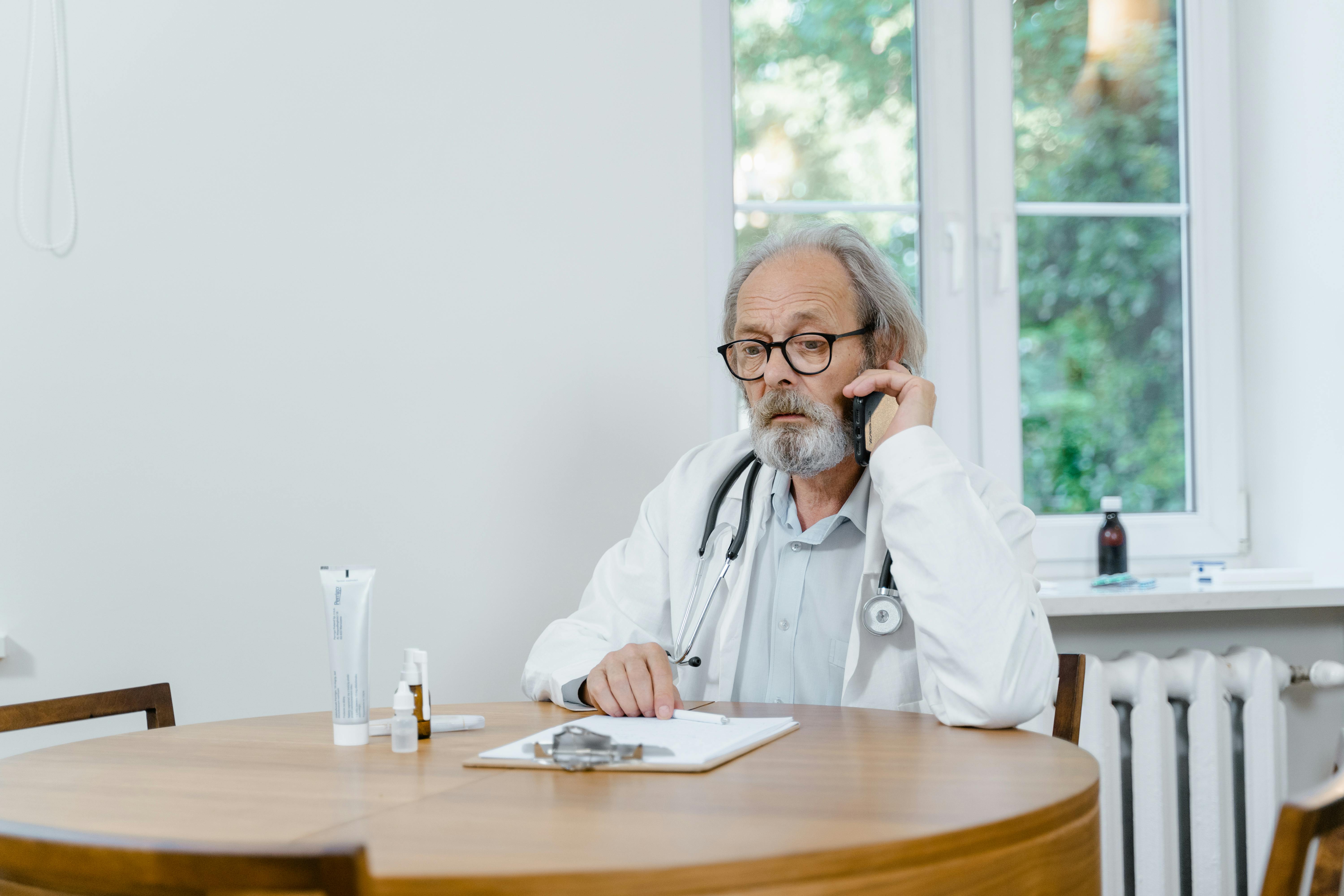 man in white dress shirt wearing eyeglasses sitting by the table