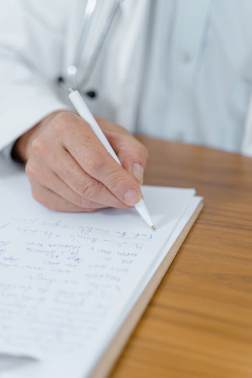 Free Close-Up Shot of Person Writing on White Paper Stock Photo