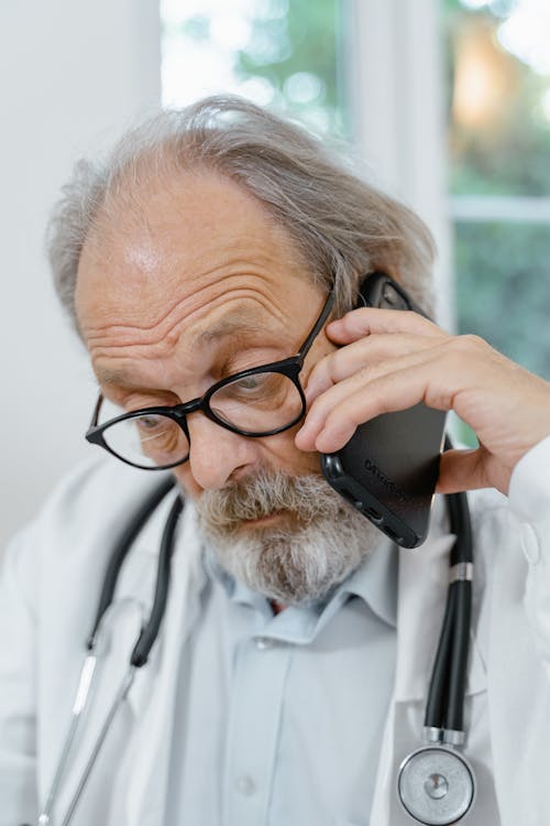 Free Close-Up Shot of Doctor Having a Phone Call Stock Photo